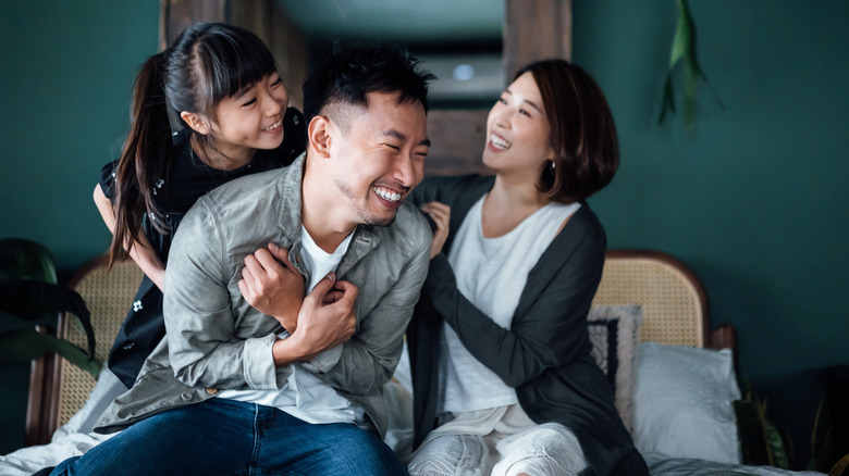 two women tickling a man