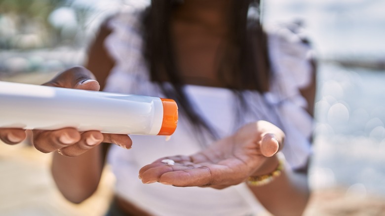 Woman squirting sunscreen into hand