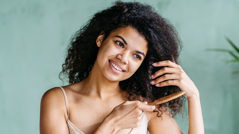 woman combing curly hair