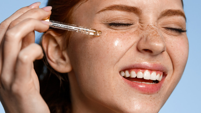 woman applying face serum