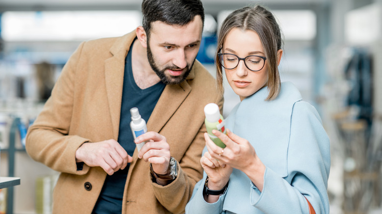 people looking at sunscreen bottles