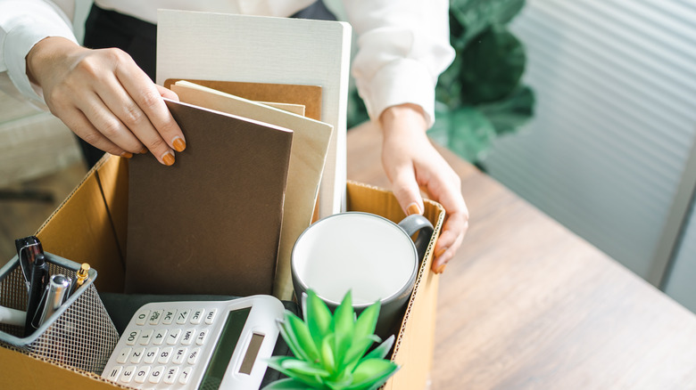 Woman packing box after losing job