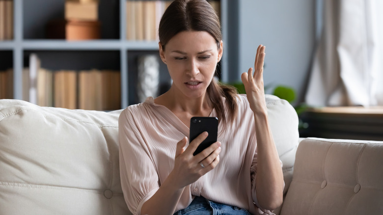 Angry woman gestures at phone