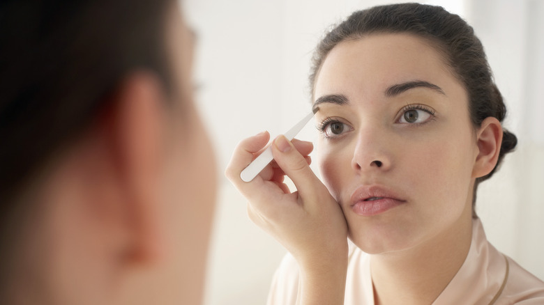 Woman doing her eyebrows