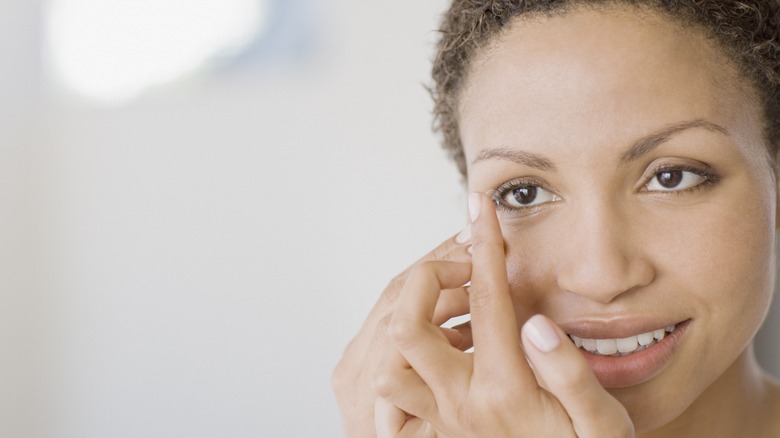 Woman inserting contact lens