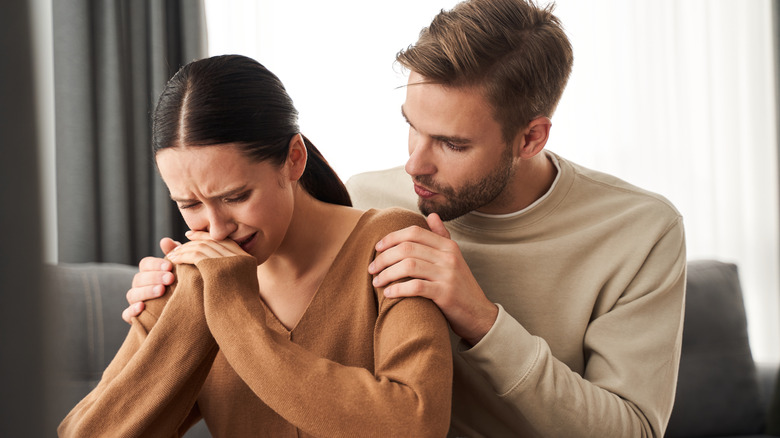 woman crying partner comforts her