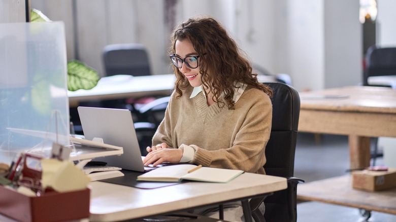 Girl sitting, working on laptop