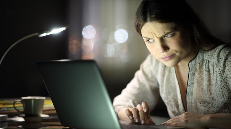 Woman suspiciously eyes laptop