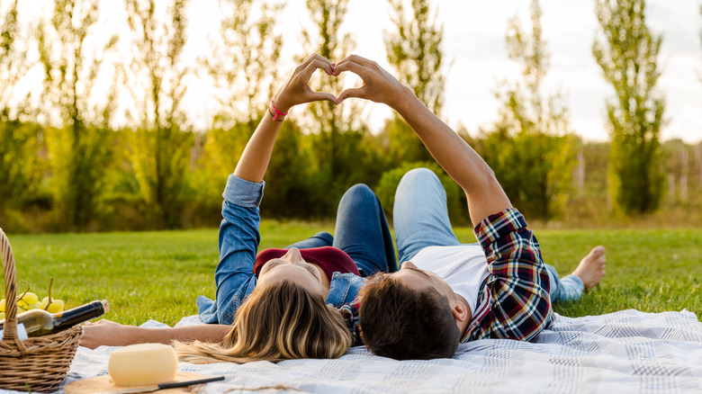 Couple lying on picnic blanket