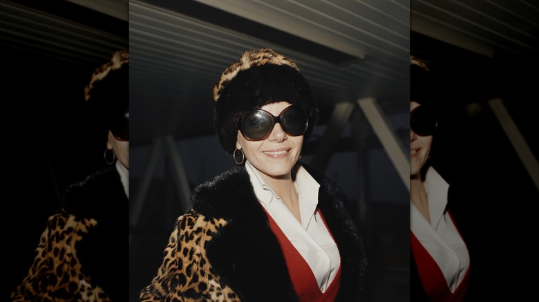 Ingrid Pitt wearing a leopard-print coat and hat as well as big sunglasses