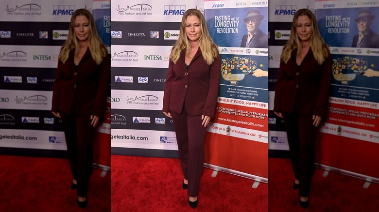 Kendra Wilkinson posing in a merlot suit in March 2026