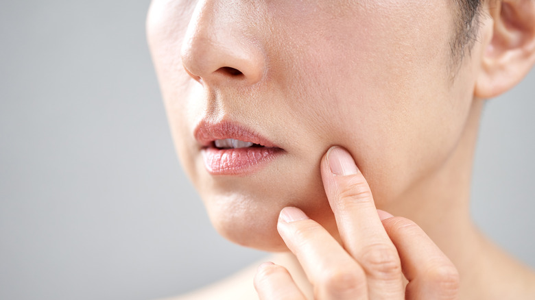 Model examining skin on face