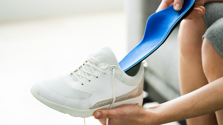 Person placing insole in shoe