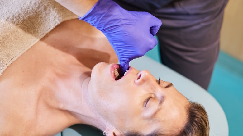 Therapist performing intraoral massage