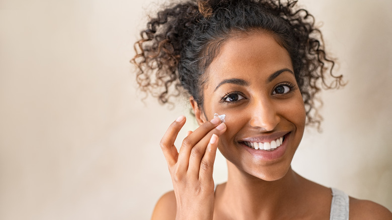 woman applying moisturizer