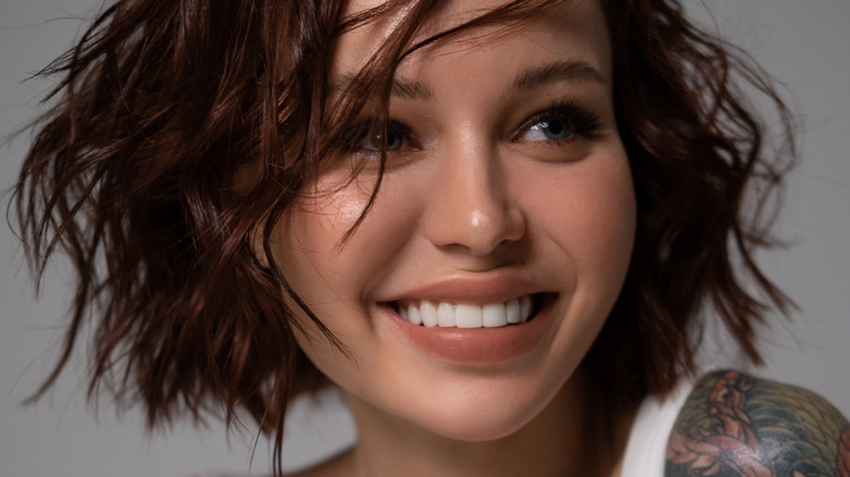 Woman with textured bob touching head