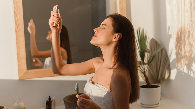 woman applying face mist 