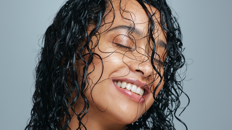 Woman smiling with wet curly hair