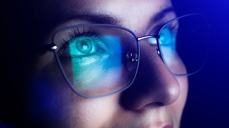 Screen reflected on woman's glasses