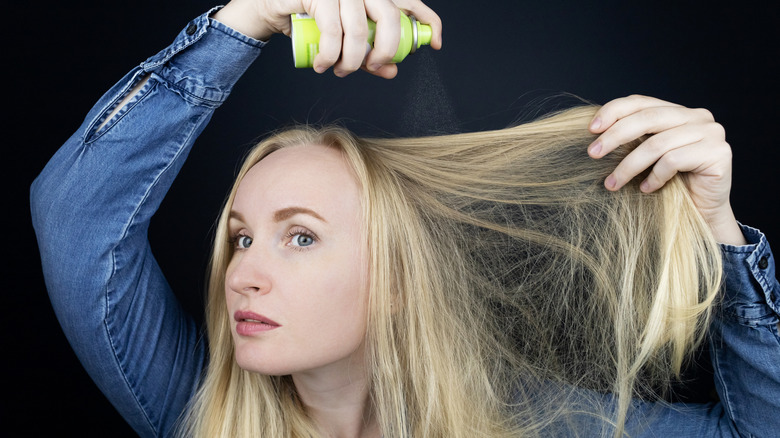 Girl sprays dry shampoo