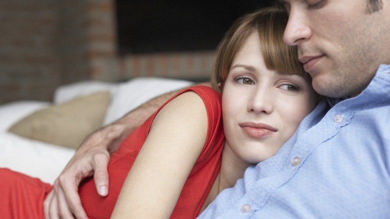 Woman looking concerned hugging man