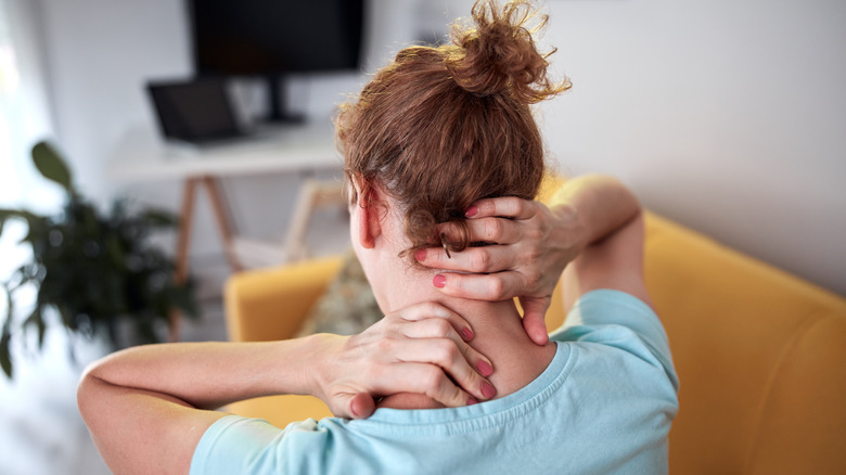 Woman scratching her neck