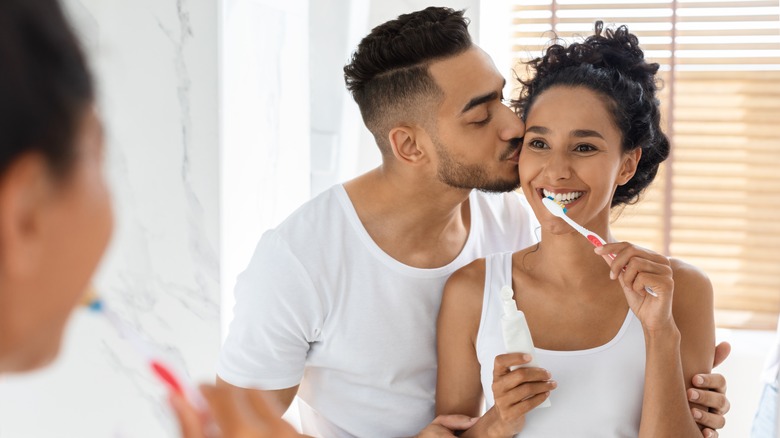 Woman brushing teeth with partner