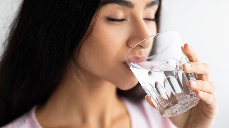 female drinking a glass of water