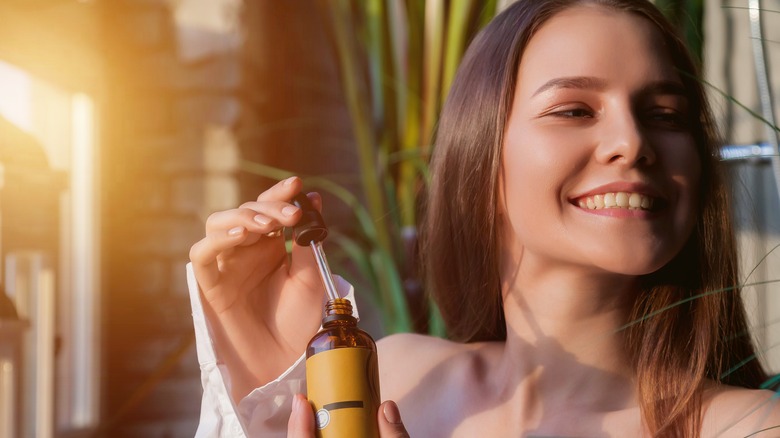 woman using serum in sunshine