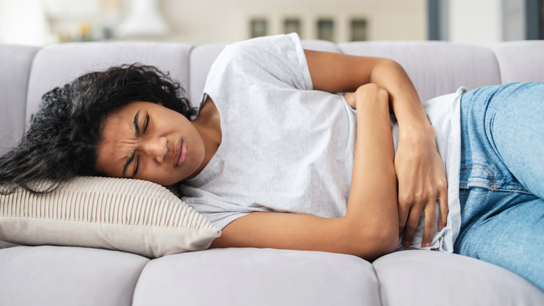 woman holding her stomach due to period cramps