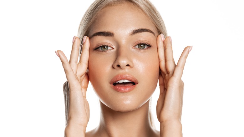 Woman applying face serum