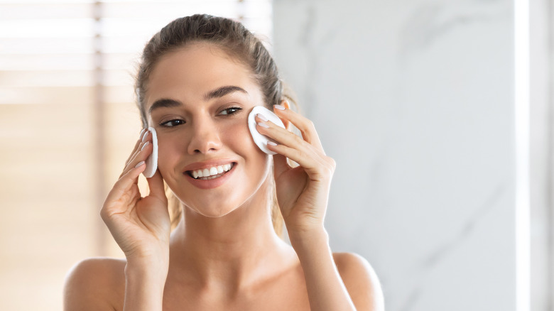 woman using cotton pads on face