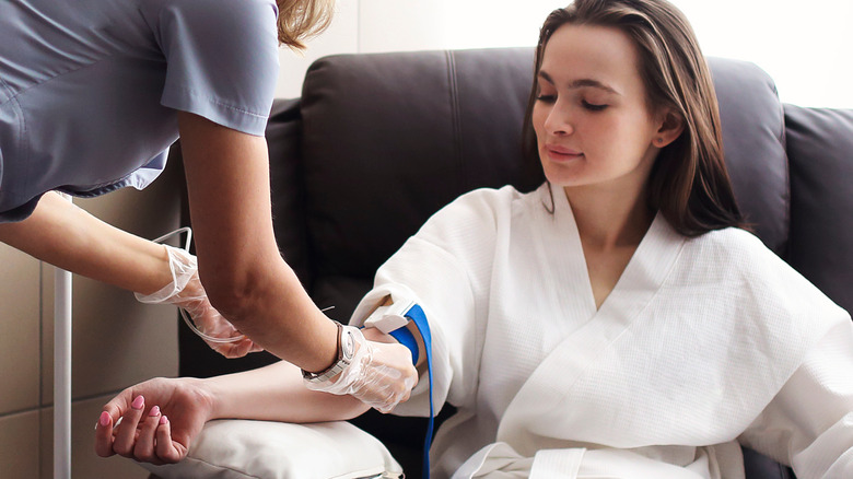 young woman receiving IV from nurse