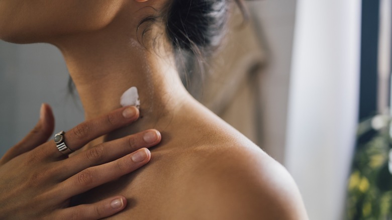 Person applying cream to neck