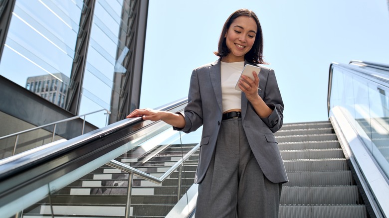 happy office woman looking at phone