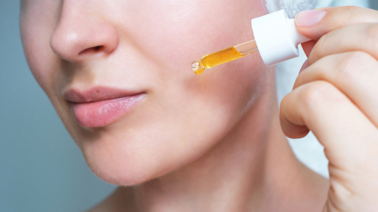 Woman applying serum with dropper