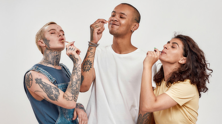 Three people eating sour candy