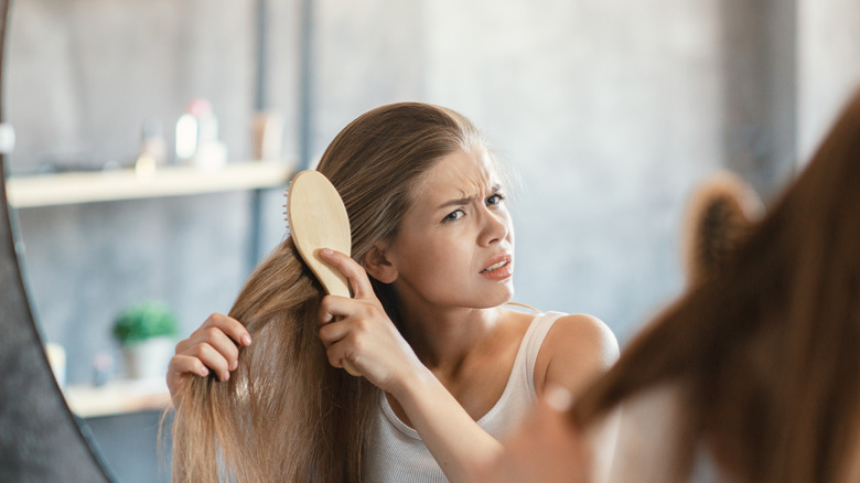 frustrated woman brushing hair