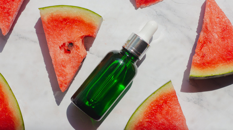 green serum bottle surrounded by watermelon pieces