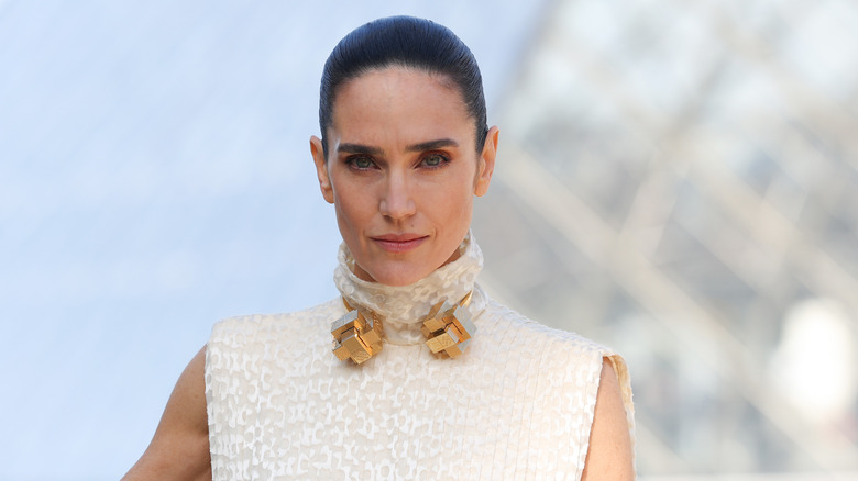 Jennifer Connelly poses in a white dress with gold necklace