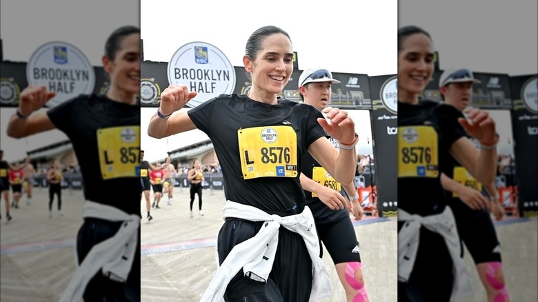 Jennifer Connelly smiles after crossing a race finish line