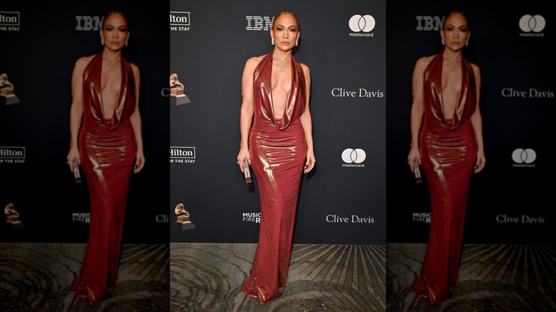 Jennifer Lopez on the red carpet wearing a red dress with a dramatic plunging neckline.
