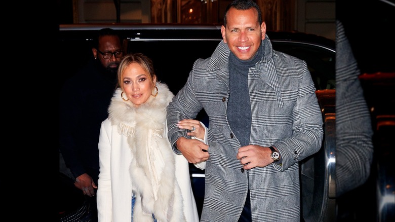 Jennifer Lopez in a white fur coat holding onto Alex Rodriguez wearing a grey peacoat.