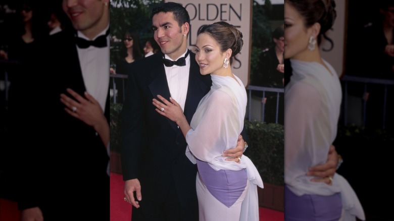 Jennifer Lopez in a white and lilac gown and a high bun with Ojani Noa with a black tuxedo.