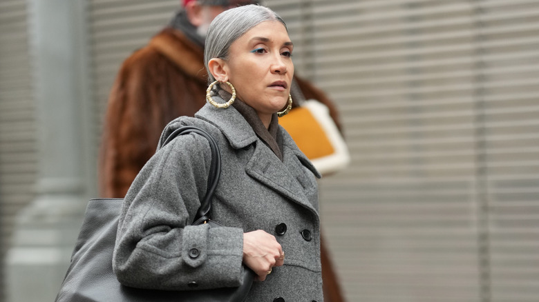 A woman wearing big hoop statement earrings