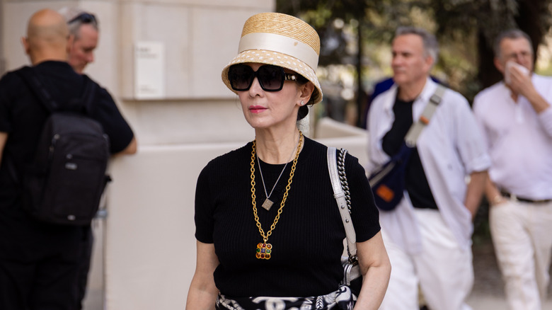 An older woman wearing layered necklaces