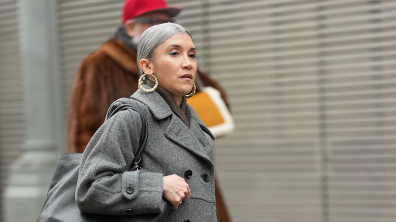A woman wearing big hoop statement earrings