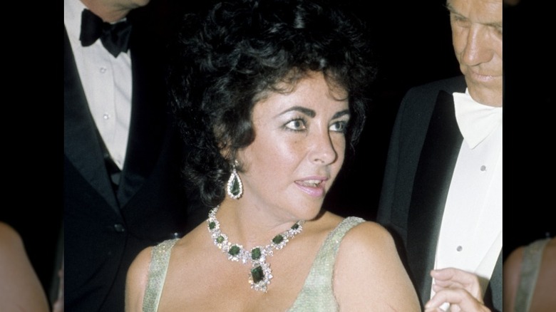 Elizabeth Taylor wearing a green dress and a crystal emerald choker