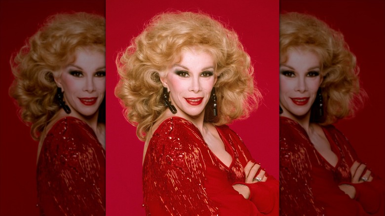 Joan Rivers smiles wearing a sparkly red dress and red lipstick.