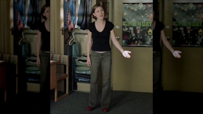 Julia Stiles in "The Prince and Me" wearing low-waisted flares, red sneakers and a black T-shirt.